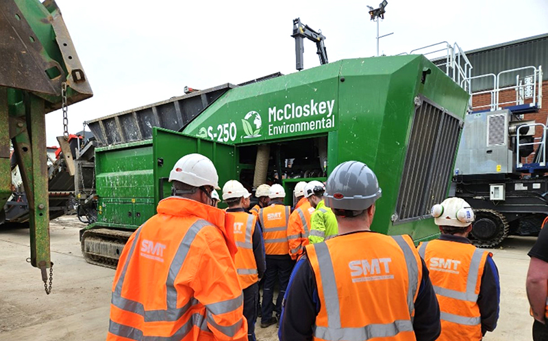 Construction workers examine an engine