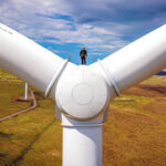 Financial close achieved on Mill Rig Wind Farm project Worker on wind turbine