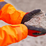 CDE webinar to focus on unlocking greater value from sand and aggregates Construction worker holding sand