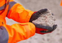 CDE webinar to focus on unlocking greater value from sand and aggregates Construction worker holding sand