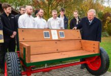 JCB apprentices mark anniversary with unique ‘listening bench’ creation Lord Bamford and JCB apprentices at Listening Bench