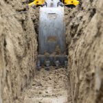 Industry hailed for new safe digging milestone Low level view of a backhoe bucket as it digs a trench