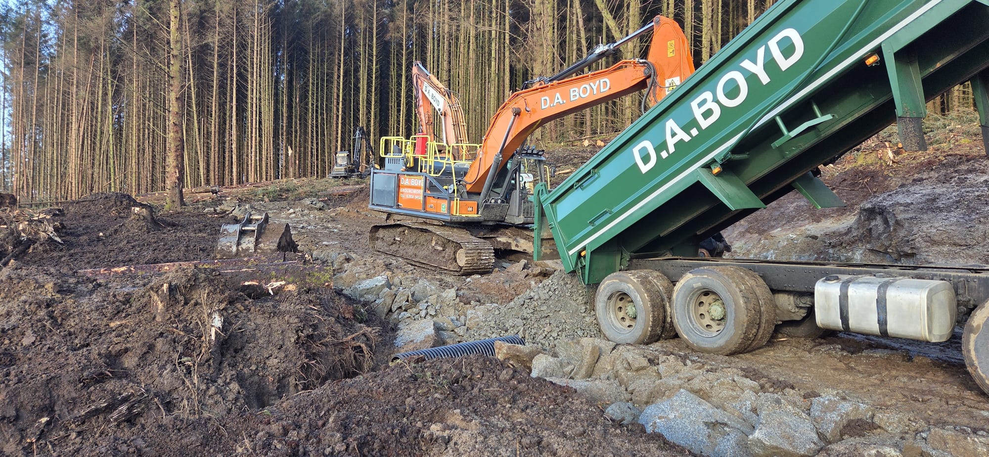 Develon excavator working in a forest
