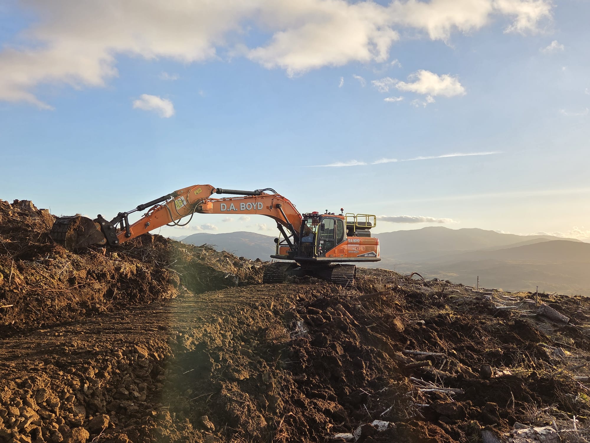 Develon excavator working on hillside