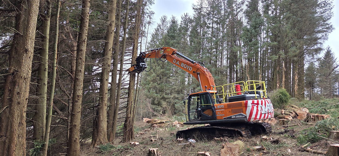 Develon excavator working in a forest