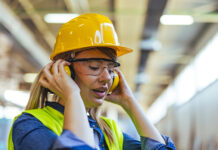 Plans unveiled for first construction-specific deaf awareness and hearing loss training programme A female worker wearing a safety helmet and earmuffs